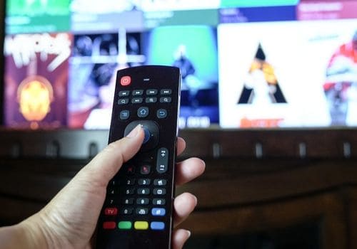 Female hand holding a smart tv remote control
